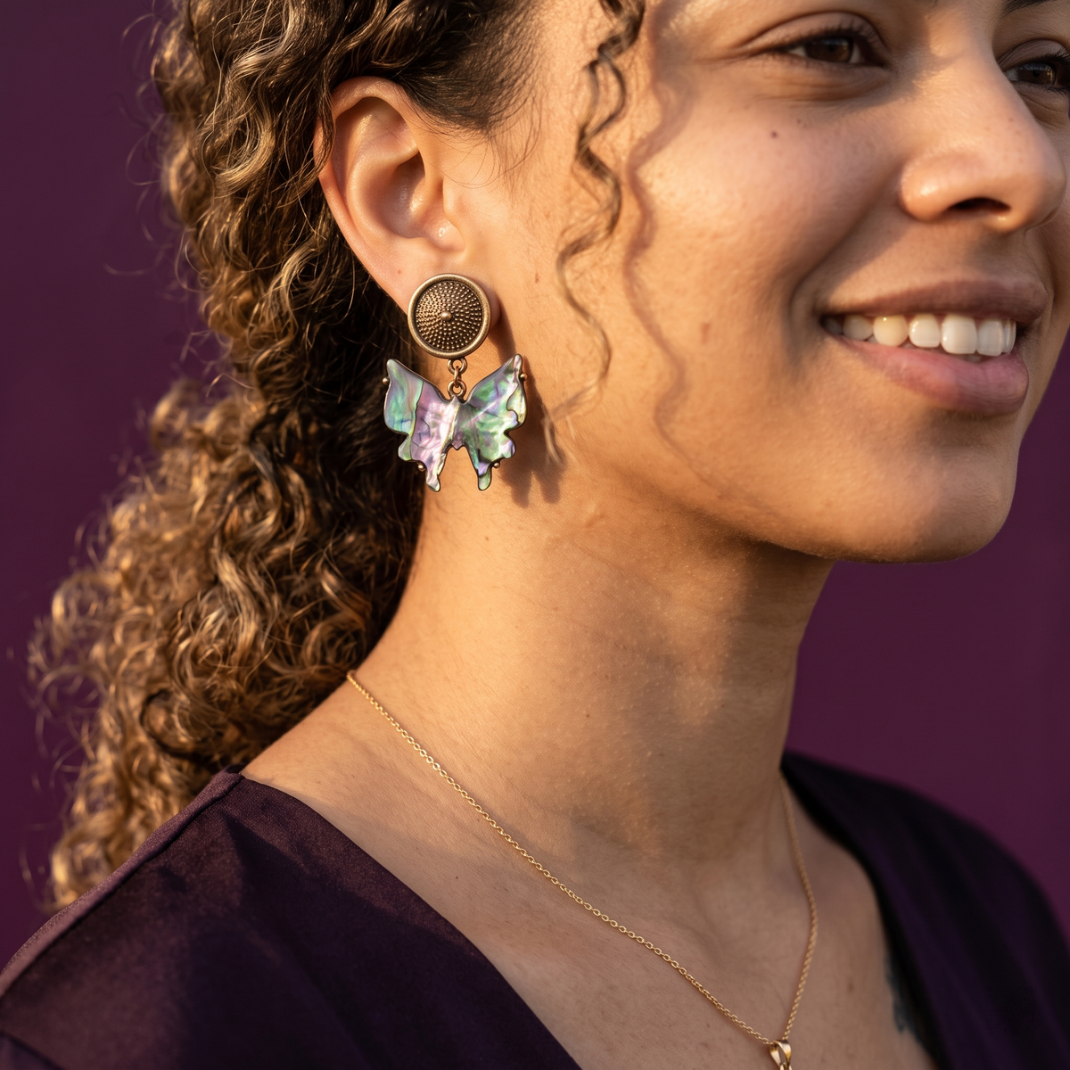 Woman wearing iridescent butterfly drop earrings with antique gold studs – multicolour party wear statement earrings for women