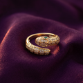 Gold crystal snake wrap ring with green eye on plum satin – adjustable serpent statement ring by Style With Anjaly