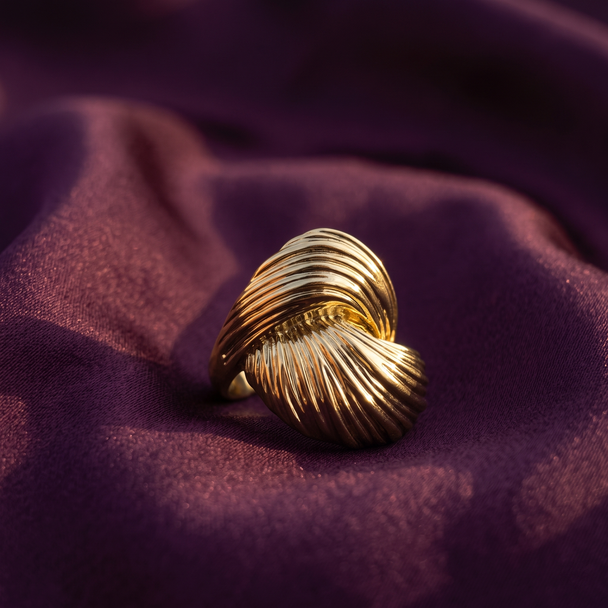 Gold swirl ribbed statement ring with sculpted shell-shaped design on plum satin – bold cocktail ring by Style With Anjaly